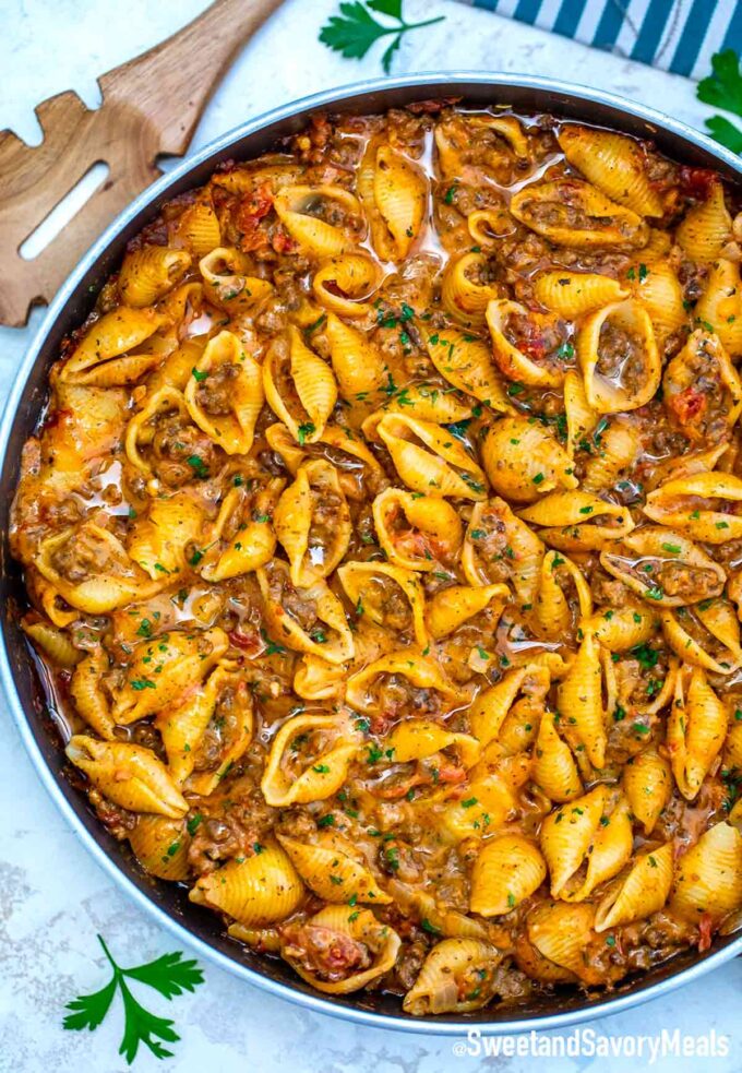 creamy beef and shells in a pan on a white table