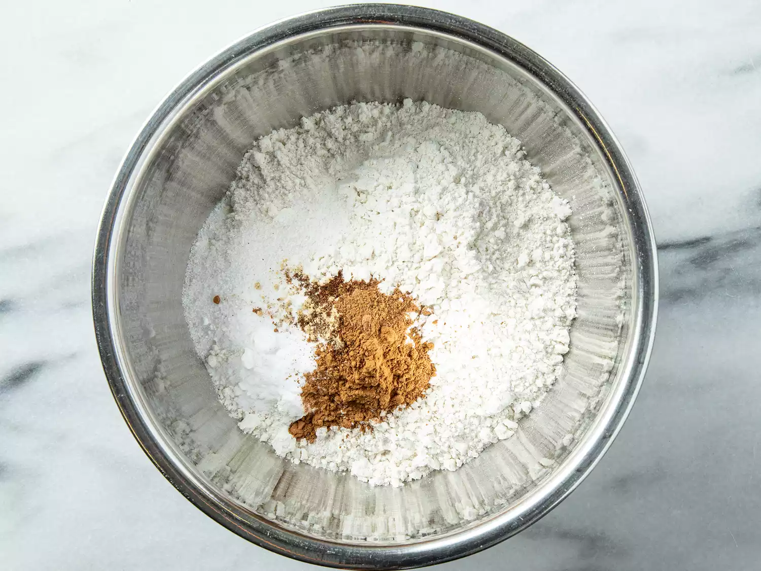Overhead of a flour, baking soda, and cinnamon mixture in a bowl. 