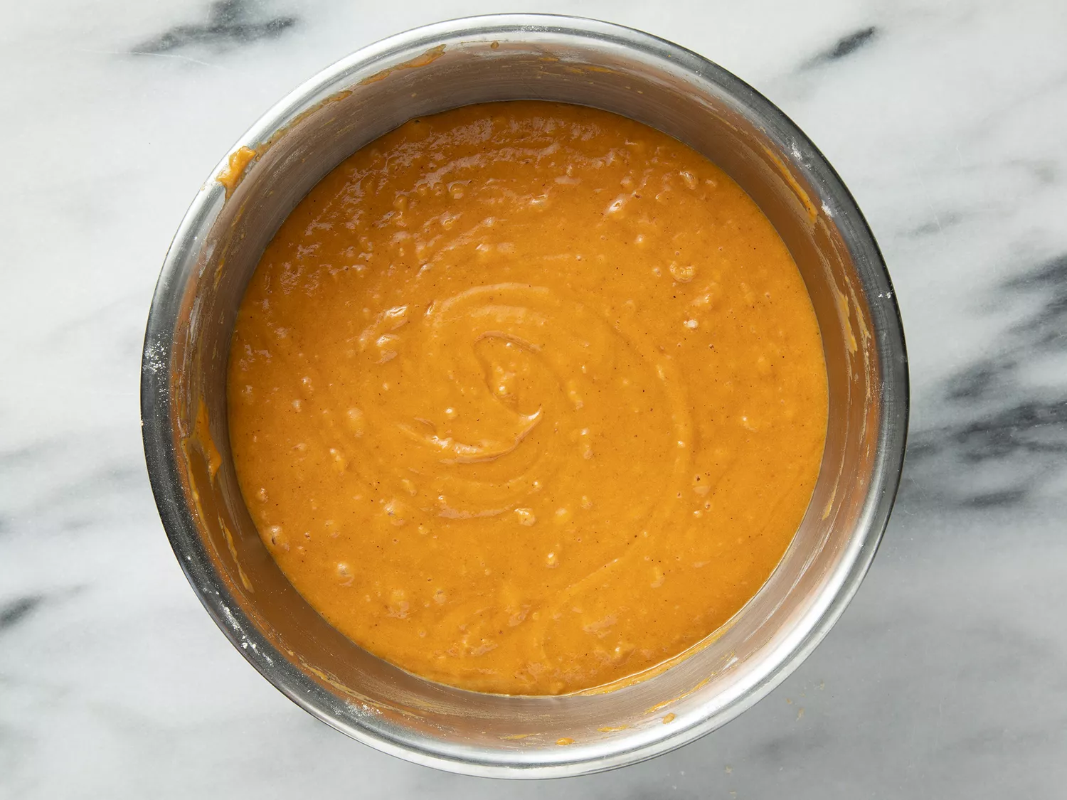 Overhead of a pumpkin batter resting in a bowl. 