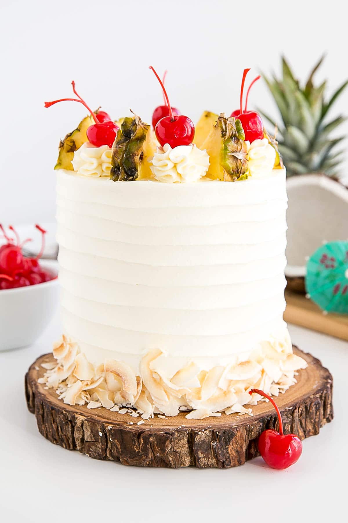 White cake with rustic frosting on a wood cake plate.