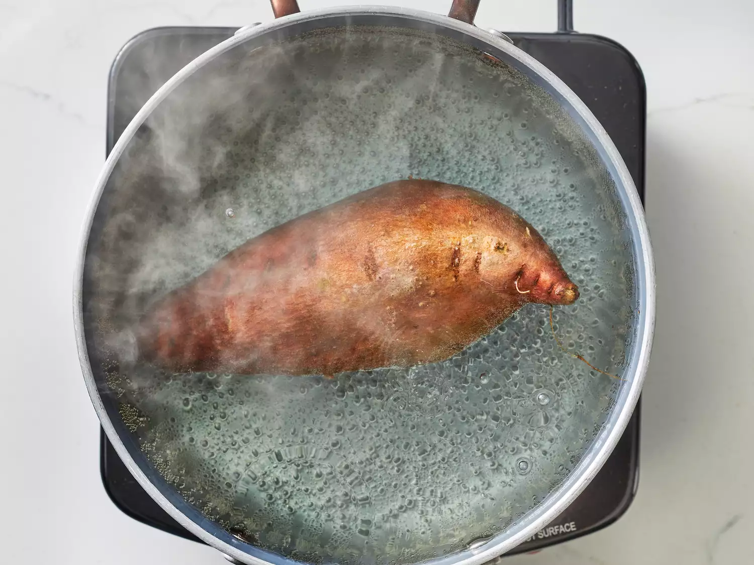 Sweet potato placed in a pot of water, coming to a boil.